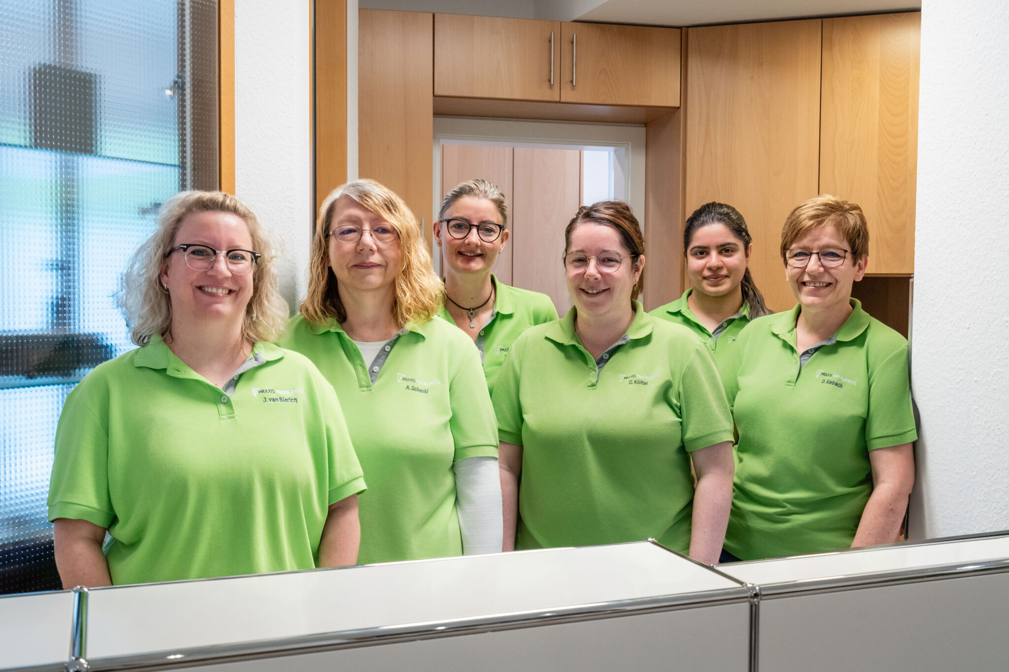 Mitarbeiterinnen posieren am Empfang.