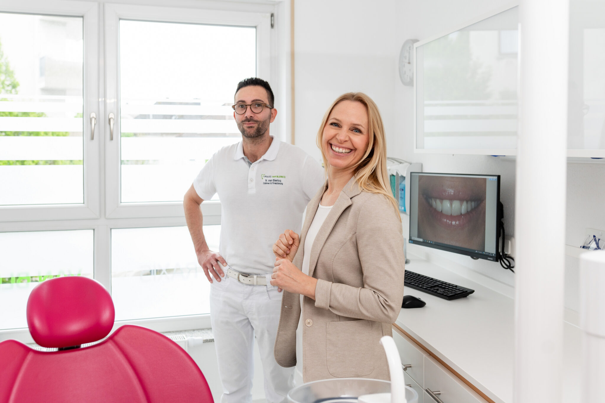 Dr. Nikolai van Blericq steht mit einer Patientin im Behandlungszimmer.